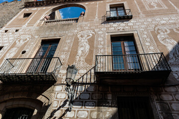 A historic building facade adorned with intricate white sgraffito artwork and traditional balconies. © @dsokol66