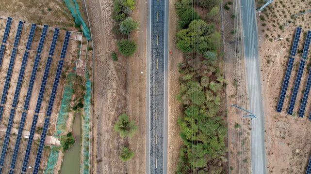 Large Scale Solar Photovoltaic Power Plant beside a River with Massive Solar Panel Arrays. Time Lapse. Establishing Shot. Aerial View.