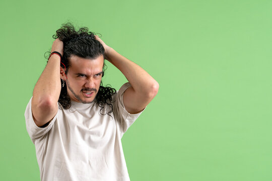 Stressed young man pulling hair feeling frustration