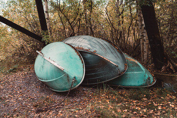 Overturned boats stored in autumn forest during off season © Valeriia