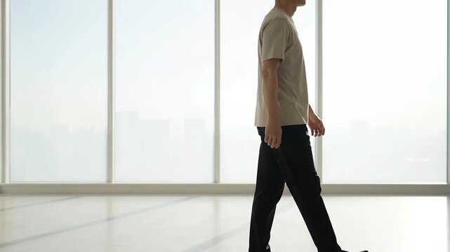 Man walking in a bright room with large captured in cinematic motion