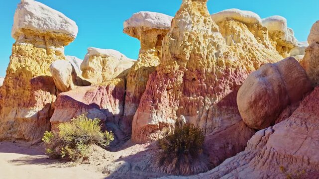 Towering white-capped hoodoo rock formations rise against a vibrant blue sky at Paint Mines Interpretive Park in Calhan, Colorado