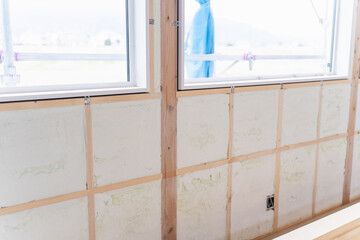 Fototapeta na wymiar 新築木造住宅の破包ウレタンの吹き付け断熱。断熱材を施工した内壁と窓まわりの下地