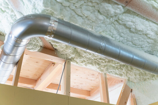 新築木造住宅の換気ダクト。換気設備と吹き付け断熱を施工した天井内部