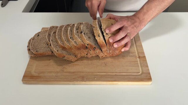 Male hands slicing freshly baked bread