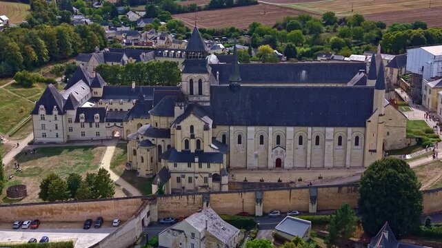 Royal Abbey of Fontevraud shows the vast abbey church and conventual buildings in Romanesque and Gothic styles, built mainly in regional tufa stone at Fontevraud-l'Abbaye during a drone slide.