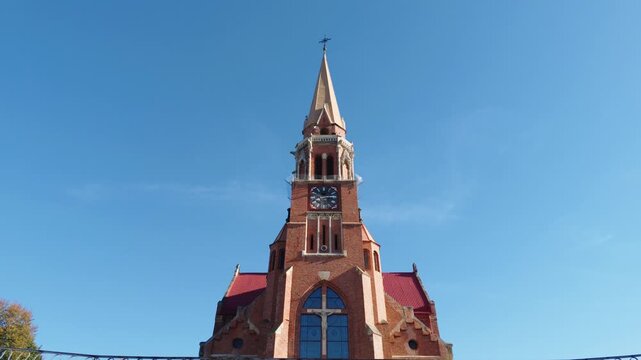 Upward-looking architectural shot of a historic church spire against a clear blue sky in Cacica, Romania.
