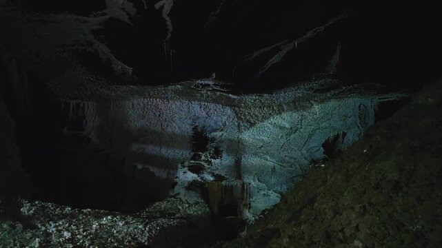 Dark atmospheric view inside an underground chamber of the Cacica salt mine, showing the historic subterranean environment.