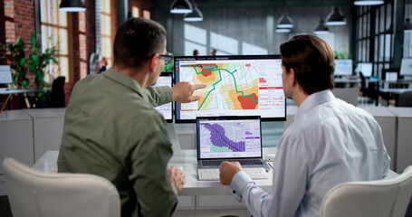 Obraz na płótnie Canvas Geospatial Analyst And Colleague Review Flood Risk Map
