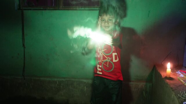 Child holding a glowing phuljhari during diwali celebrations