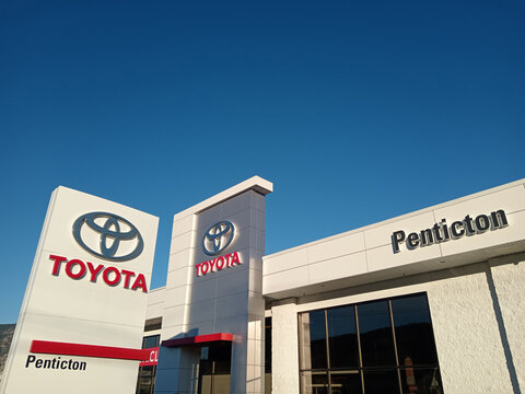 Penticton, Canada - June 22, 2026: The exterior of a Toyota dealership in Penticton Canada shows several vehicles for sale. The brand logo is visible on the building.