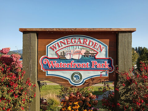 Gibsons, Canada - September 8, 2026: Winegarden Waterfront Park signage is seen in Gibsons, British Columbia, Canada with boats in the harbor.