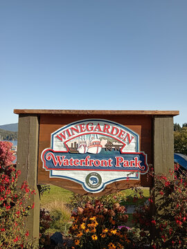 Gibsons, Canada - September 8, 2026: Winegarden Waterfront Park signage is seen in Gibsons, British Columbia, Canada with boats in the harbor.