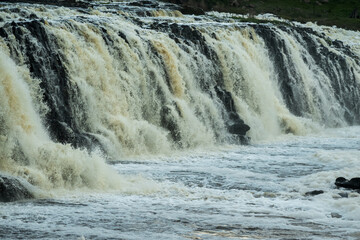 Powerful waterfall plunges over rugged rock formations, its sediment-tinted cascades creating dense spray and turbulent whitewater across rocky river below, Hopkins Falls, Cudgee, Victoria, Australia © Quincy