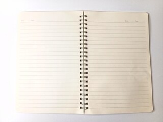 Open spiral notebook with lined cream pages lay flat on a clean white background. © iizztt
