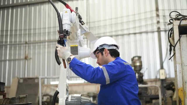 Engineer factory industry wearing safety uniform work and checking system of the welding robots for welding steel electrical by control system robot automate for industry manufacture concept.	