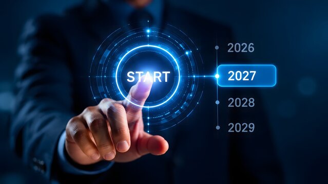 Businessman pressing a virtual start button on a futuristic interface to initiate the year 2027, representing new beginnings and strategic planning for the future.