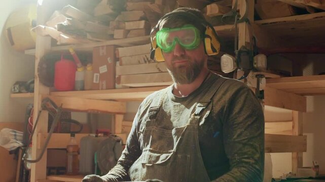 Man inspects wood piece while surrounded by joinery equipment. Workshop shelves hold lumber boxes lighting creates warm atmosphere joiner woodworker tools