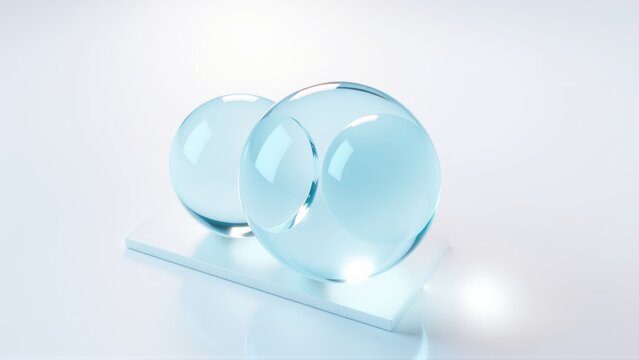 Clear glass orbs rest upon reflective surface. Minimalist composition, bright lighting, smooth textures present. Simple, elegant design.