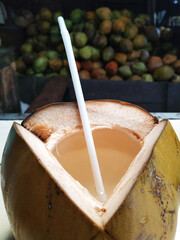 Fresh Coconut Water Served in a Natural Coconut Shell for Tropical Summer Refreshment. A natural tropical beverage for summer refreshment, hydration, and healthy lifestyle concepts. © pakdheokim