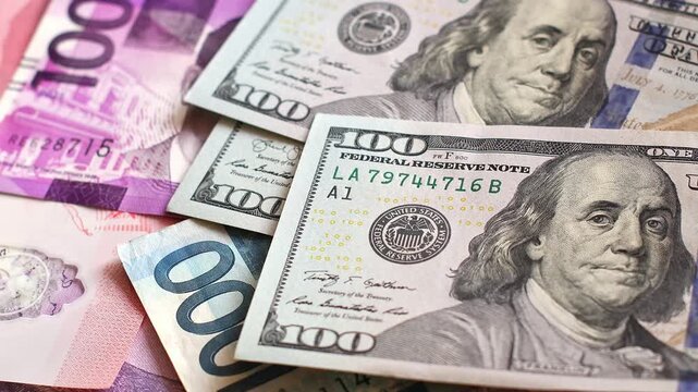 American 100 dollar bills falling onto Philippine peso banknotes. US cash lands across colorful local denominations, illustrating overseas remittances, global trade and personal wealth