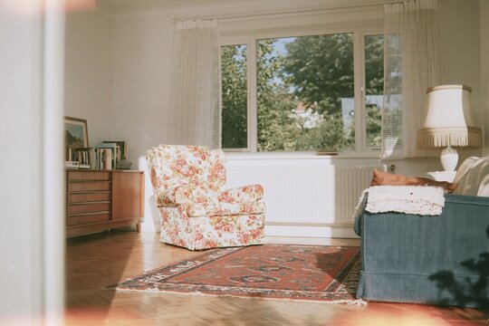 Floral armchair in a cozy 1970s living room with warm amber light and vintage furniture, perfect for nostalgic home decor and interiors