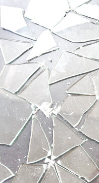 Shattered glass fragments with sharp edges and realistic reflections on a transparent background, broken window or mirror effect
