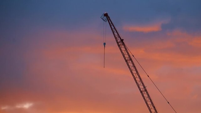 Time-lapse Construction Crane Silhouette Against Dramatic Sunset Clouds
