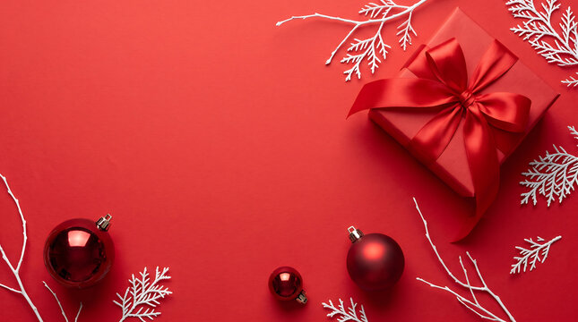Festive red background with gift box ornaments and silver winter foliage