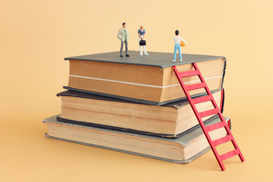Stack of books and miniature figures. education and learning concept