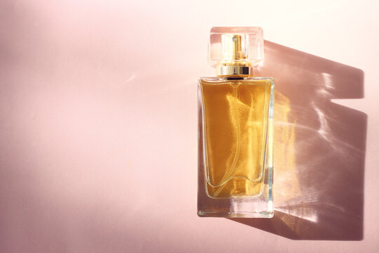 Top view image of perfume bottle on pink pastel background