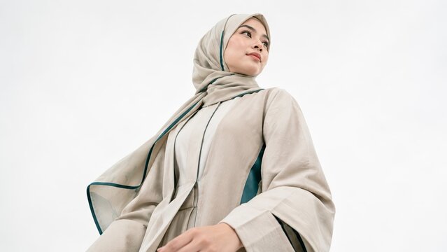 Portrait of a confident woman wearing a beige hijab and coat in