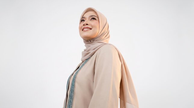 Professional woman in beige hijab smiling confidently against plain