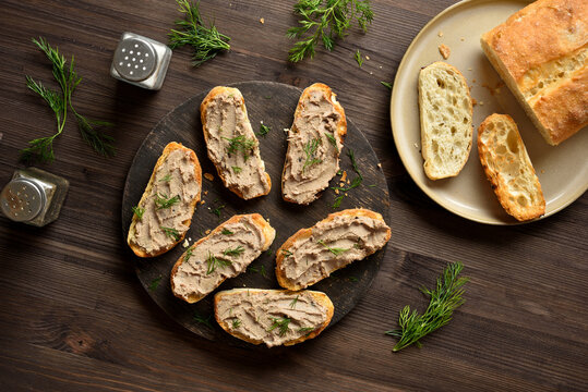 Appetizer liver pate on toasted bread on cutting board