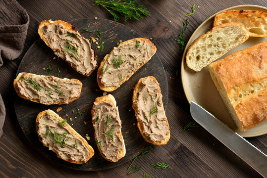 Appetizer liver pate on toasted bread on cutting board