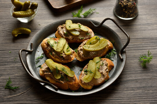 Open sandwiches with liver pate on wooden background