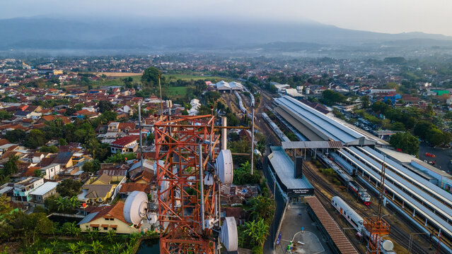 Aerial View of Telecommunication Tower with Radio Masts and Equipment Near a Railway Station in the Morning in Purwokerto, Central Java, Indonesia.