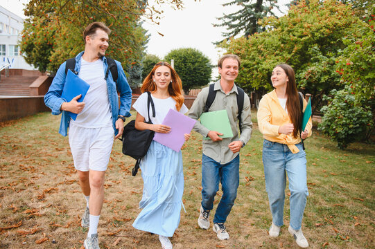 Group of students walking happily on university campus