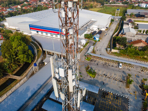 Aerial View of a Telecommunication Tower with Radio Masts and Equipment Near a Retail Warehouse in the Morning in Purwokerto, Central Java, Indonesia.