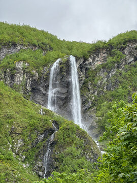 Tall waterfall on a green mountain, Krasnaya Polyana, Russia