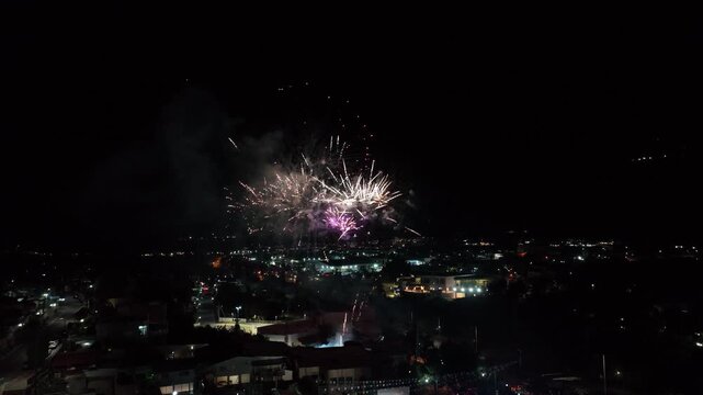 Fireworks exploding in the night sky over a city skyline
