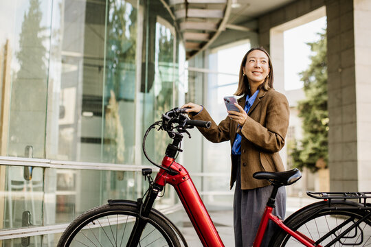 Korean woman enjoying her electric bicycle ride in a modern setting