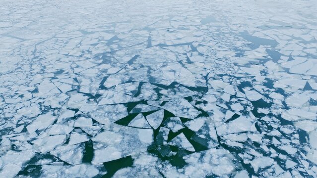 Aerial View of Small Ice Floes Drifting on a Frozen River