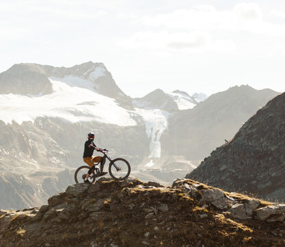 Mountain Biker Posing Below an Alpine Glacier