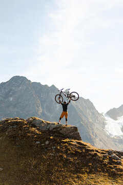 Mountain Biker Posing Below an Alpine Glacier