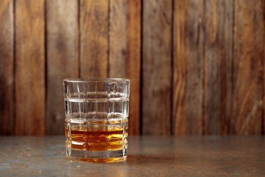 Whisky is poured from a decanter into a crystal glass.