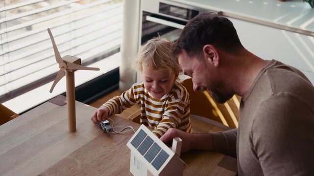 Father educating toddler about solar power and eco friendly living.