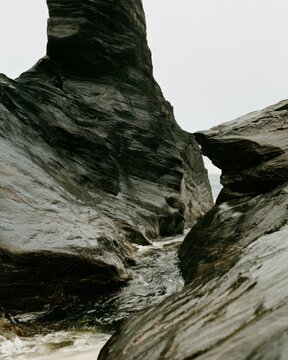 Dramatic dark rock formation and narrow sea channel on rugged coast