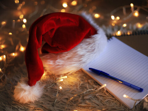 Santa hat and notebook, Christmas stationery and holiday planning with gift wish lists and letters to Santa.