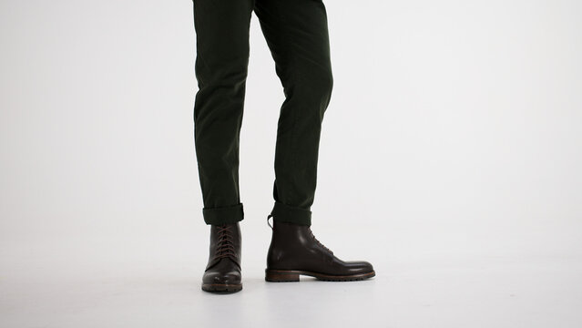 Man wearing dark green chinos and brown leather lace-up boots, showcasing autumn and winter fashion style